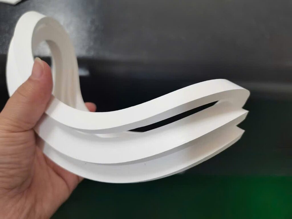 Chi tiết teflon uốn dạng lượn sóng cầm trên tay