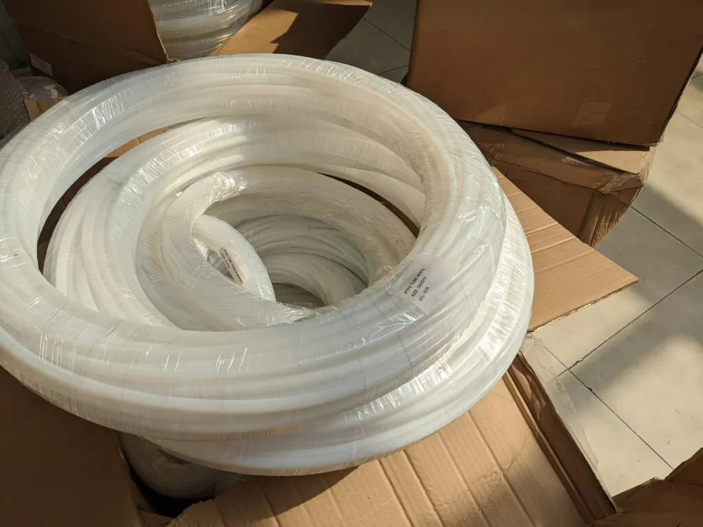 Cuộn ống teflon trắng xếp trong thùng các tông