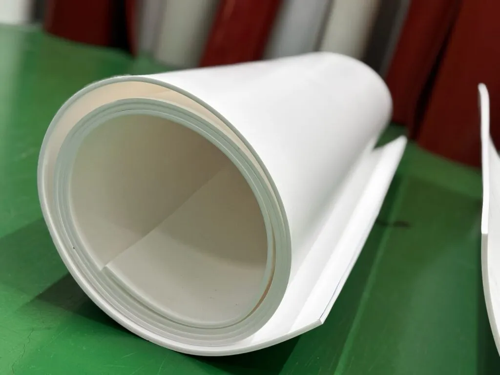 Cuộn tấm teflon trắng đặt trên sàn xanh