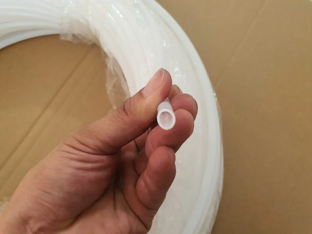 Đầu ống teflon nhỏ cầm giữa các ngón tay