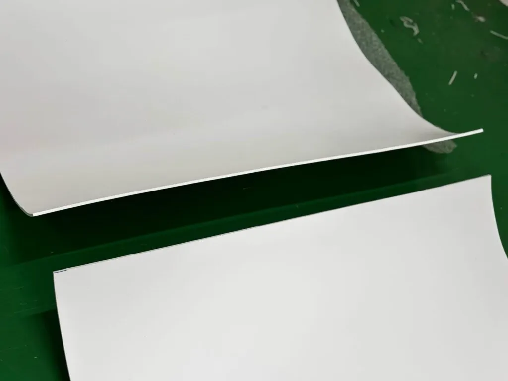 Hai tấm teflon trắng mỏng uốn cong trên sàn