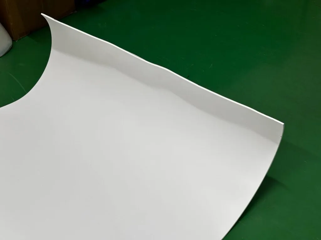 Mép tấm teflon mỏng cong lên trên sàn xanh