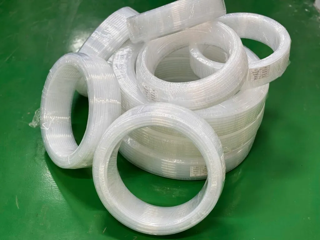 Nhiều cuộn ống PFA nhỏ xếp trên tấm xanh