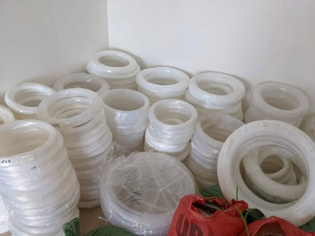 Nhiều cuộn ống teflon trắng xếp trên sàn kho