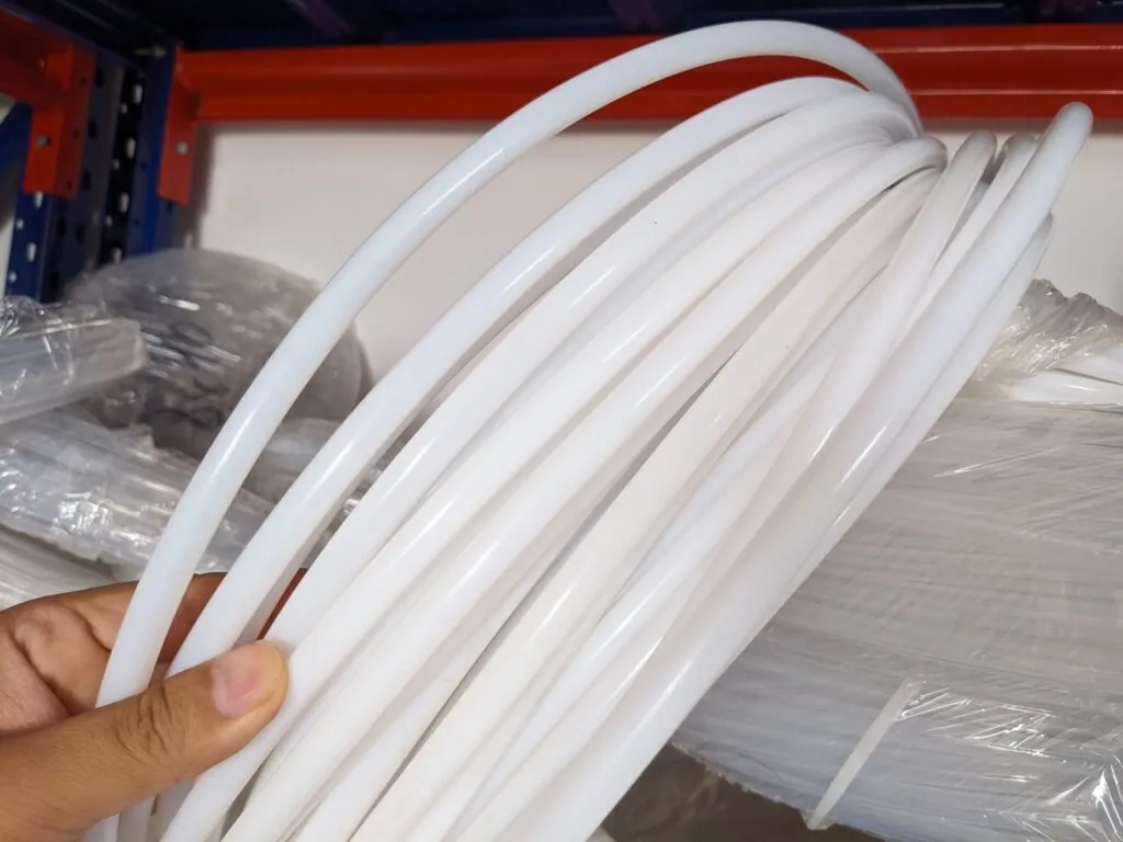 Nhiều sợi ống teflon trắng uốn vòng cầm trên tay