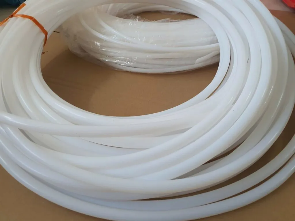 Nhiều vòng ống teflon trắng mảnh xếp trên bìa giấy