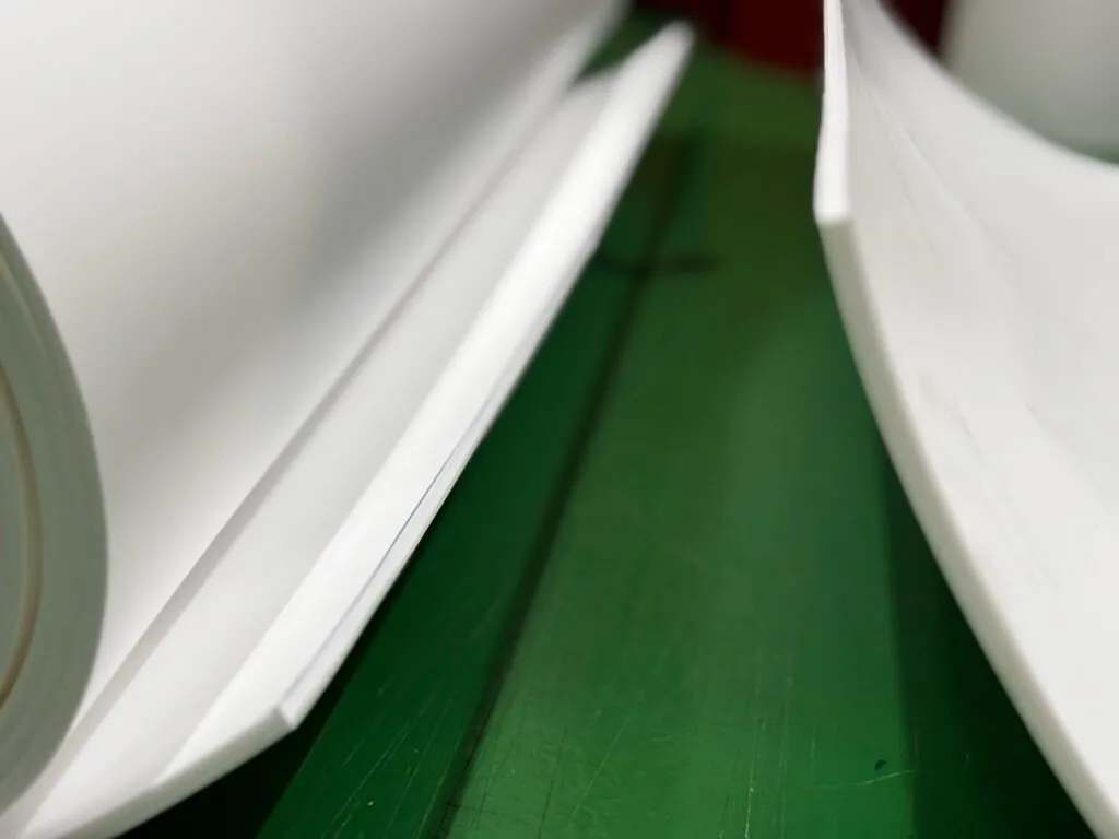 Tấm teflon trắng dựng đứng trên sàn xanh