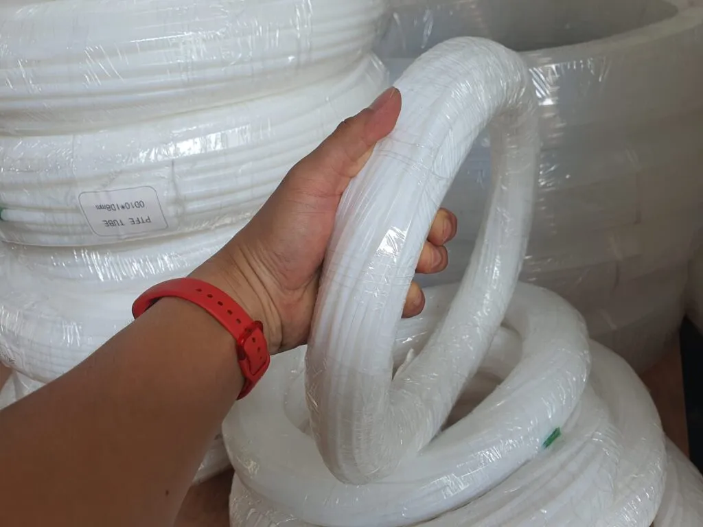 Tay cầm cuộn ống teflon trắng nhỏ bên cạnh chồng cuộn