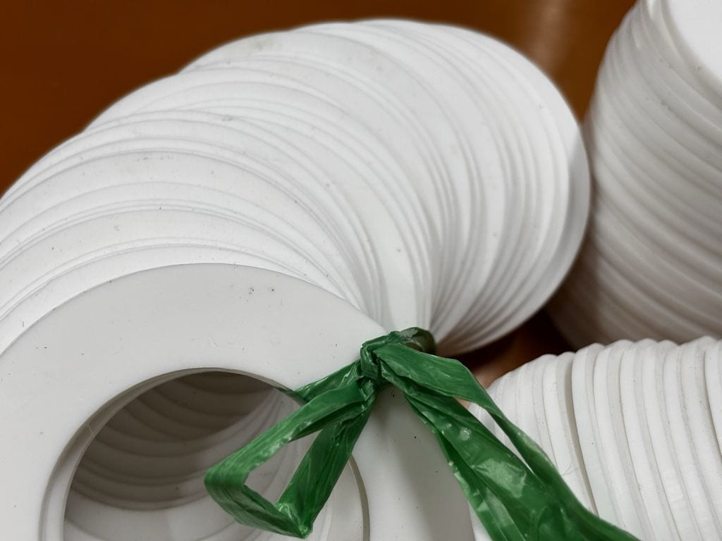 Xấp gioăng teflon kín mặt cầm trên tay nhìn từ cạnh